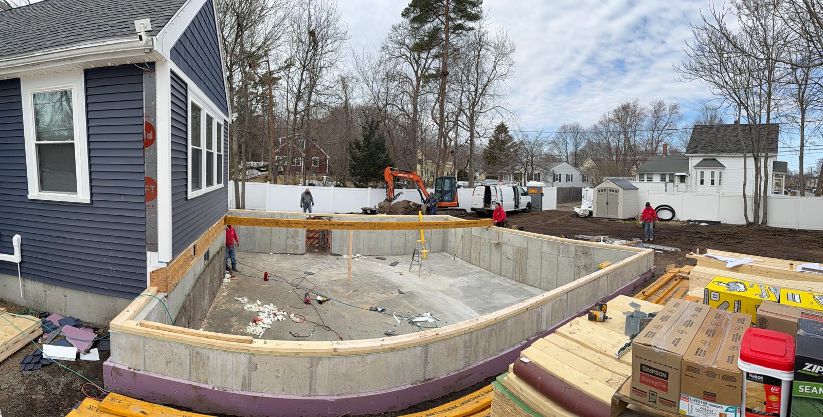 Concrete foundation walls for the home addition beside the original house