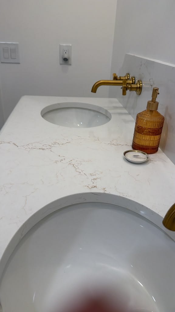 Bathroom vanity with wall mounted brass colored faucets