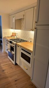 White kitchen cabinetry, wood countertops and Café range in Hudson MA